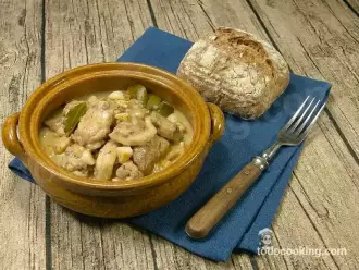 pollo al ajillo en cazuelita con pan y tenedor