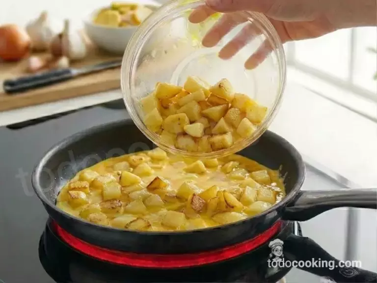 Cuajando la tortilla de patatas en una sartén Cuajando la tortilla de patatas en una sartén