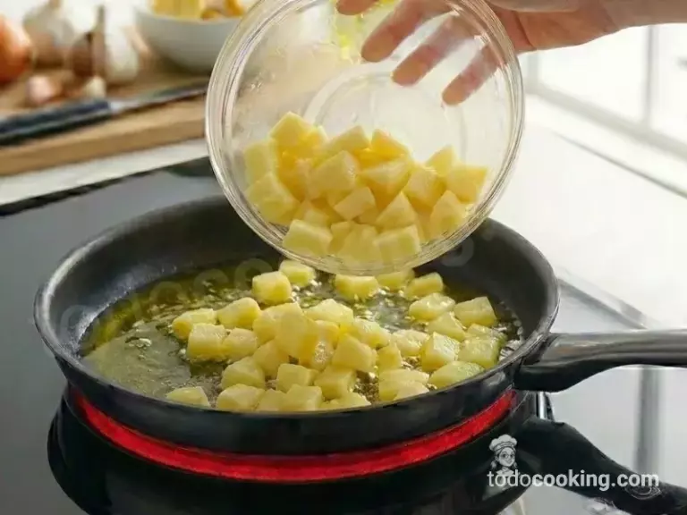 Dorando patatas para hacer una tortilla de patatas en sartén Dorando patatas para hacer una tortilla de patatas en sartén