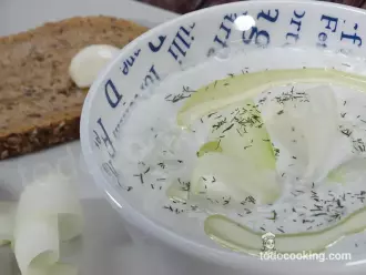 Sopa fría de pepino y yogur griego servida en un bol con eneldo fresco y láminas de pepino.