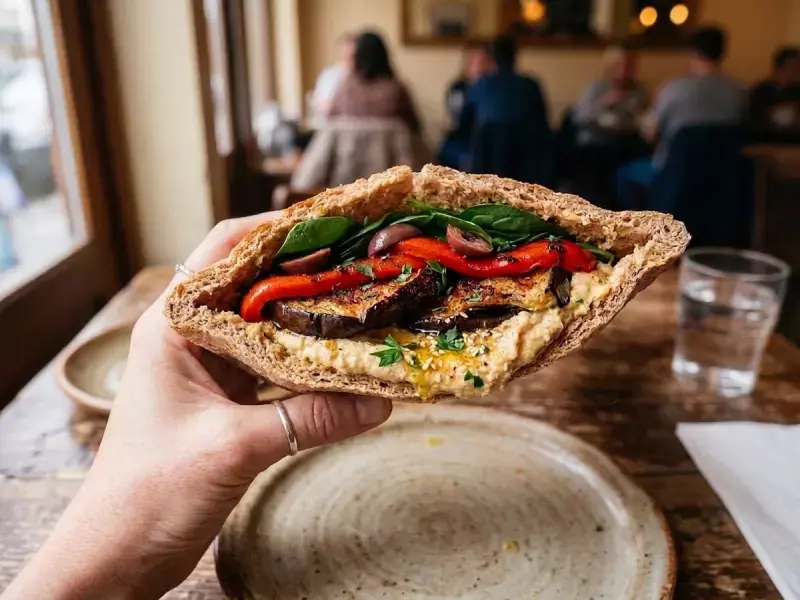 Pan de pita relleno de berenjena asada, hummus, piquillo, espinacas y za'atar